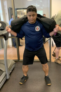 Firefighter lifting weighted bag, exercising